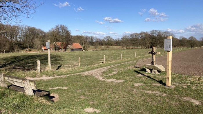 landkruis met bankje kijkend naar hennie